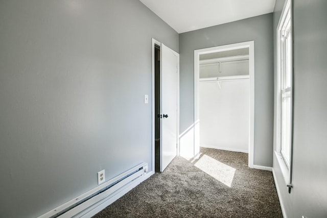 unfurnished bedroom with baseboard heating, a closet, baseboards, and carpet
