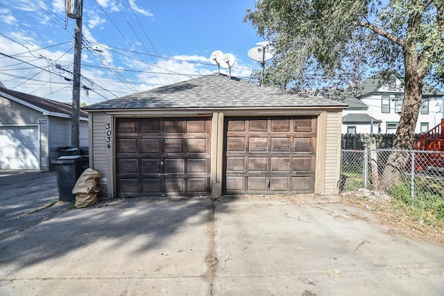 detached garage featuring fence