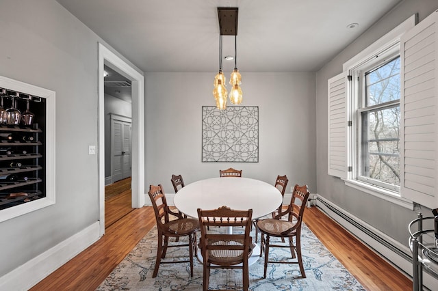 438 Portland Ave Unit 7, Saint Paul, MN 55102 - dining room with a baseboard heating unit, light wood-style floors, a chandelier, and baseboards