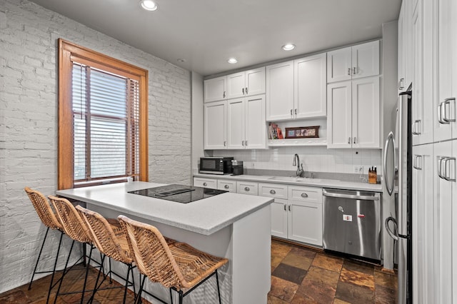 438 Portland Ave Unit 7, Saint Paul, MN 55102 - kitchen with black appliances, a sink, white cabinetry, a breakfast bar area, and recessed lighting