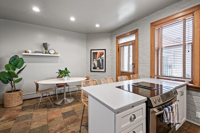 438 Portland Ave Unit 7, Saint Paul, MN 55102 - kitchen featuring stainless steel range with electric cooktop, white cabinetry, recessed lighting, light countertops, and a breakfast bar area