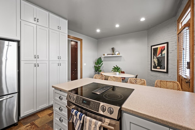 438 Portland Ave Unit 7, Saint Paul, MN 55102 - kitchen featuring appliances with stainless steel finishes, recessed lighting, stone tile floors, white cabinetry, and light countertops