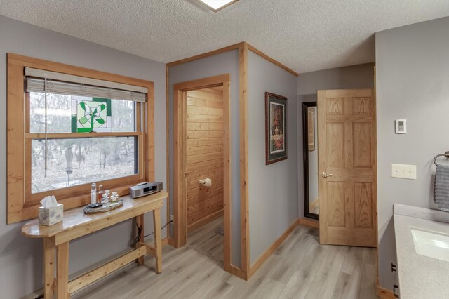 12124 County Road 118, Merrifield, MN 56465 - hall featuring light wood-type flooring, a sink, baseboards, and a textured ceiling