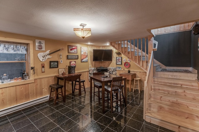 12124 County Road 118, Merrifield, MN 56465 - dining room with a wainscoted wall, a baseboard heating unit, stairway, wooden walls, and granite floors
