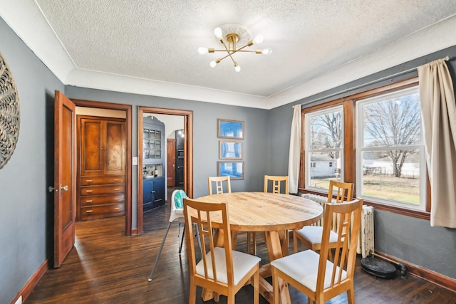 dining room with a chandelier, a textured ceiling, dark wood-style flooring, and baseboards