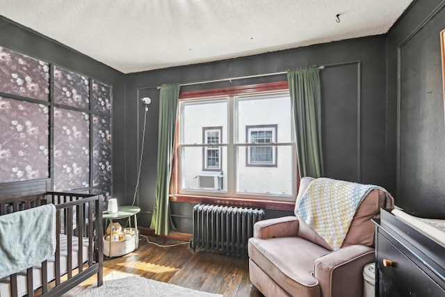 interior space with cooling unit, hardwood / wood-style floors, radiator, and a textured ceiling