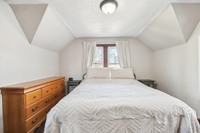 bedroom with a textured ceiling and vaulted ceiling
