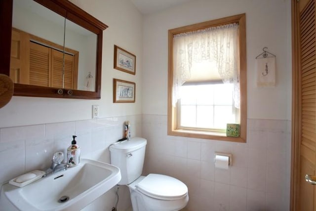 20437 County Highway 65, Henning, MN 56551 - half bath featuring tile walls, a sink, toilet, and a wainscoted wall