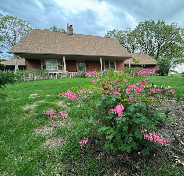 20437 County Highway 65, Henning, MN 56551 - view of front of house featuring a chimney, a front yard, a porch, and roof with shingles