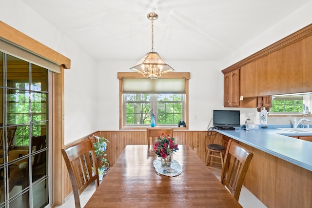 20437 County Highway 65, Henning, MN 56551 - dining space featuring a wainscoted wall, a chandelier, healthy amount of natural light, and wooden walls