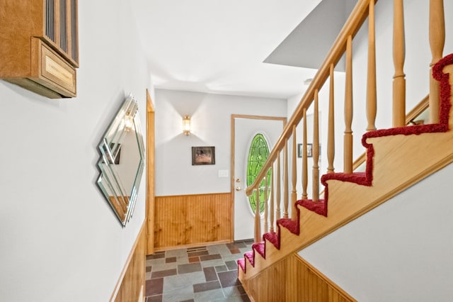 20437 County Highway 65, Henning, MN 56551 - foyer entrance featuring a wainscoted wall, wooden walls, stairs, and dark stone finish floors