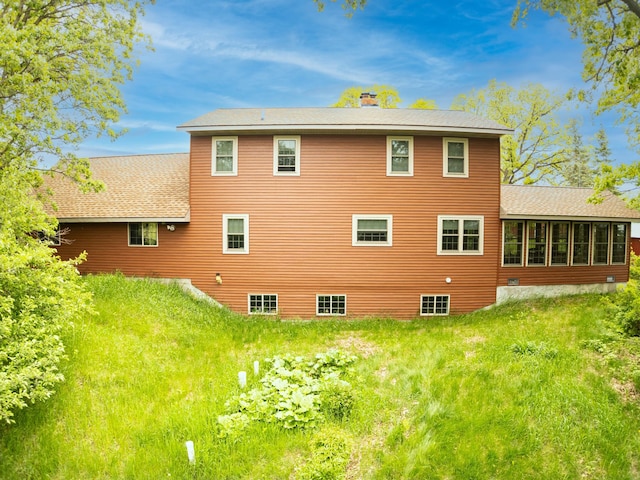 20437 County Highway 65, Henning, MN 56551 - back of house featuring a chimney, a sunroom, roof with shingles, and a yard