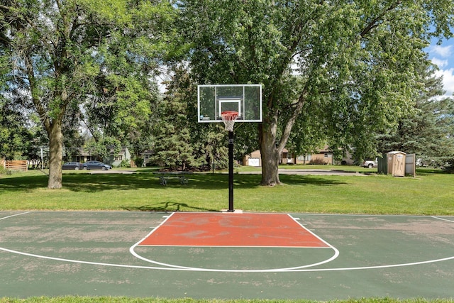 view of basketball court featuring community basketball court, a yard, and view of scattered trees