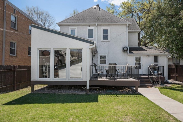 back of house featuring a shingled roof, stucco siding, a wooden deck, and fence