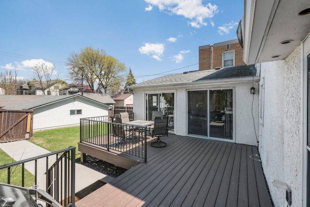 wooden deck with a yard and outdoor dining space