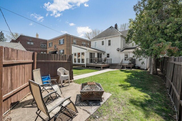 view of yard with a patio, a fenced backyard, an outdoor fire pit, and a wooden deck