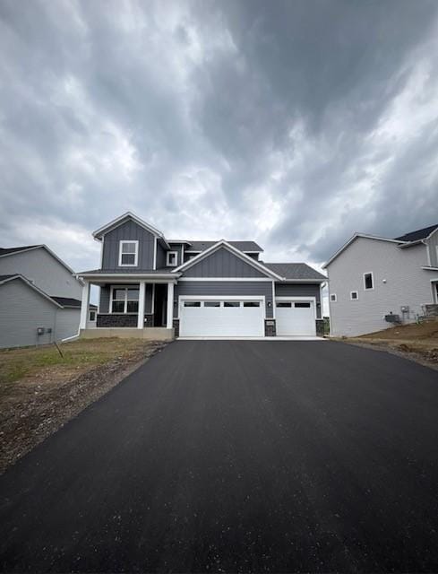 14570 Kingsview Ln N, Dayton, MN 55327 - craftsman-style house with an attached garage, asphalt driveway, and board and batten siding