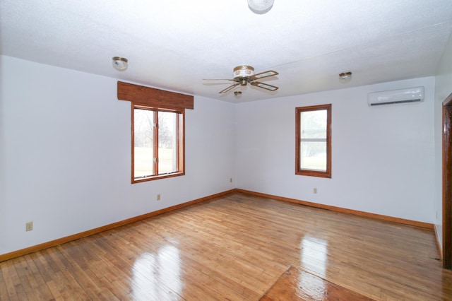 18848 223rd St, Richmond, MN 56368 - unfurnished room featuring a wall mounted AC, ceiling fan, baseboards, and a healthy amount of sunlight