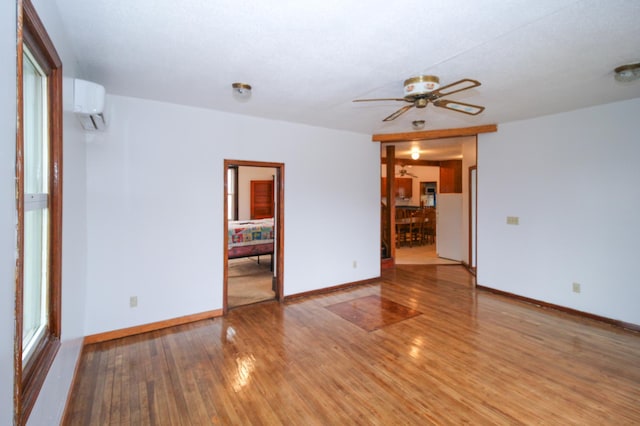 18848 223rd St, Richmond, MN 56368 - spare room with light wood finished floors, ceiling fan, an AC wall unit, and baseboards