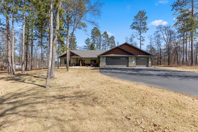 16605 Piper Ln, Brainerd, MN 56401 - view of front facade with stone siding, an attached garage, driveway, and covered porch