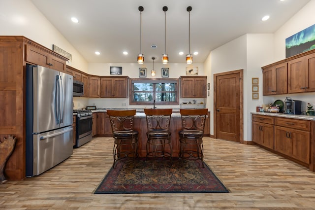 16605 Piper Ln, Brainerd, MN 56401 - kitchen with stainless steel appliances, light wood finished floors, a breakfast bar, a center island, and pendant lighting