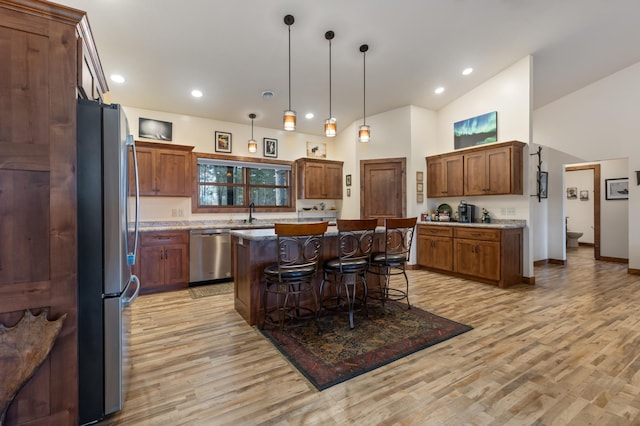 16605 Piper Ln, Brainerd, MN 56401 - kitchen featuring appliances with stainless steel finishes, a center island, a breakfast bar area, light wood-type flooring, and high vaulted ceiling
