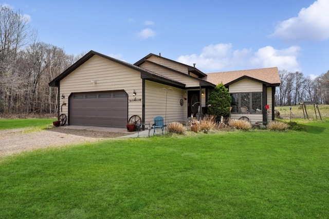 ranch-style house featuring a garage, a front lawn, and driveway