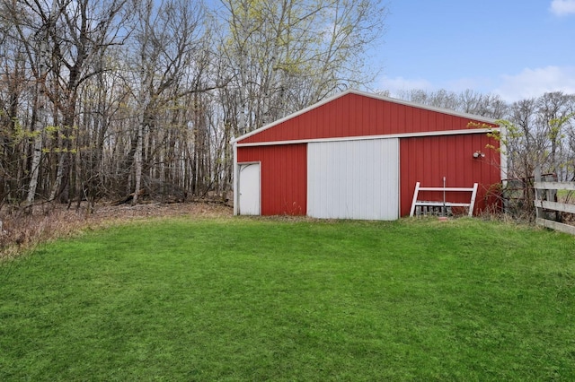 view of pole building with a lawn and fence