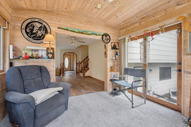 sitting room with wood ceiling, wood walls, stairway, carpet floors, and lofted ceiling