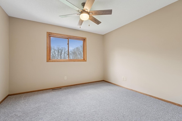 unfurnished room featuring baseboards, ceiling fan, carpet, and visible vents