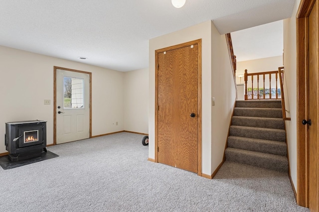 interior space with baseboards, a wood stove, and stairway