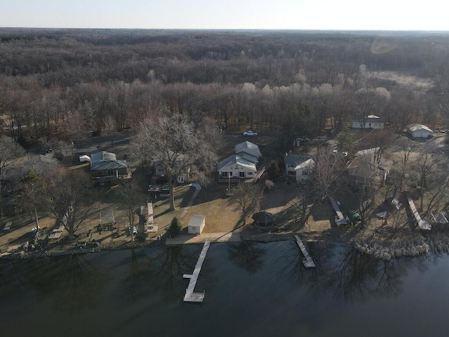 view of property location with a heavily wooded area and nearby suburban area