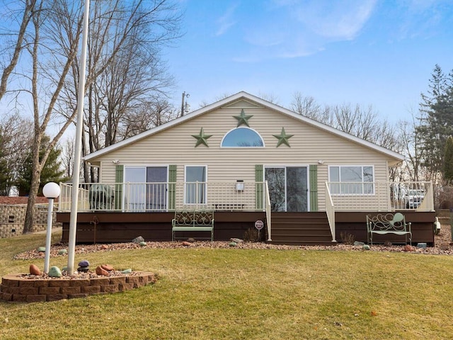 rear view of property with a deck and a yard