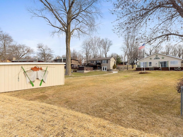 view of grassy yard with an outbuilding and a wooden deck