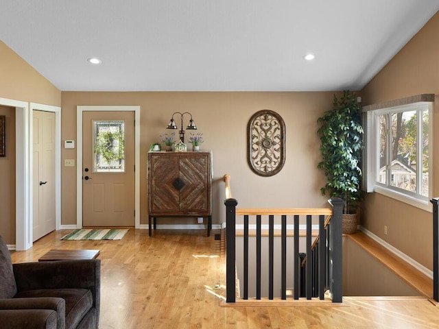 foyer entrance with vaulted ceiling, wood finished floors, baseboards, and recessed lighting