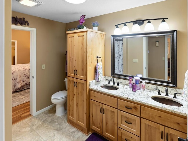 bathroom featuring ensuite bathroom, double vanity, and toilet