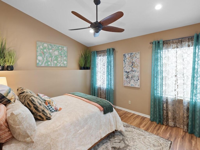 bedroom with wood finished floors, lofted ceiling, baseboards, a ceiling fan, and recessed lighting