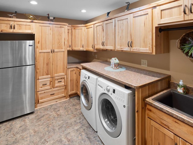 clothes washing area featuring washing machine and clothes dryer, a sink, and recessed lighting