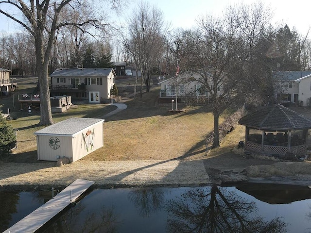 view of grassy yard featuring a gazebo and an outbuilding
