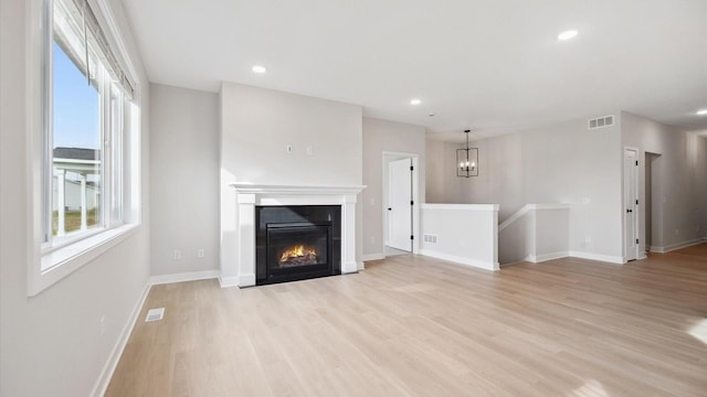 unfurnished living room with light wood-style flooring, baseboards, visible vents, and recessed lighting