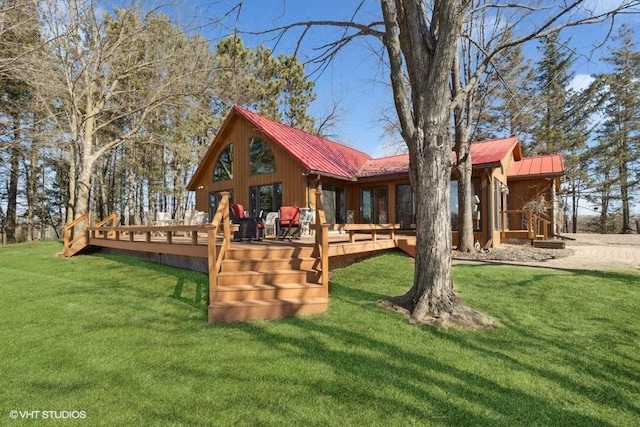 back of property with a yard, metal roof, and a wooden deck
