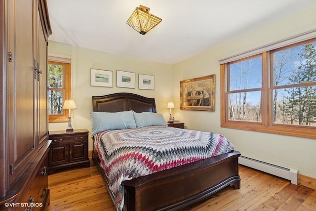 bedroom featuring baseboard heating and light wood-style flooring