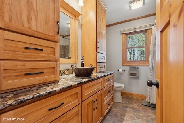 full bathroom with baseboards, toilet, heating unit, crown molding, and stone finish flooring