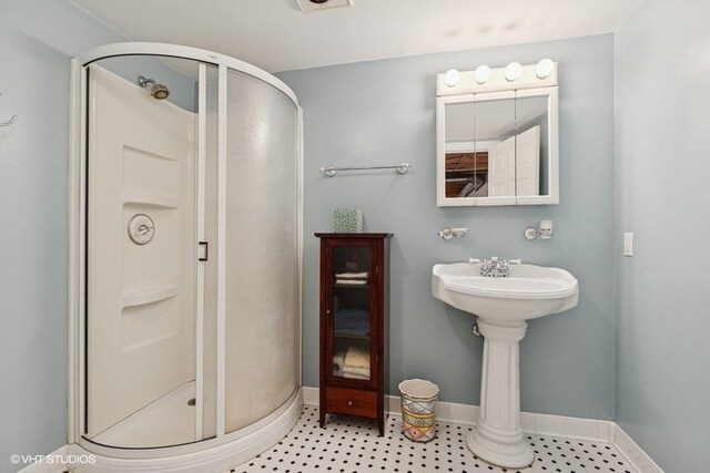 bathroom featuring baseboards and a shower stall