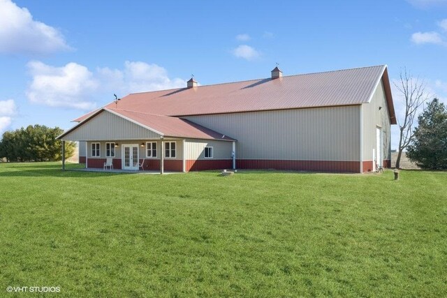 rear view of property featuring a yard, metal roof, and french doors