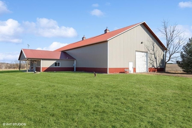 exterior space featuring a yard, a garage, a pole building, and an outbuilding