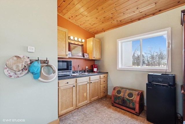 kitchen with black microwave, dark countertops, wood ceiling, a sink, and light brown cabinetry