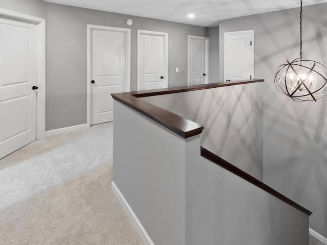 hallway featuring baseboards, an upstairs landing, a chandelier, recessed lighting, and light colored carpet