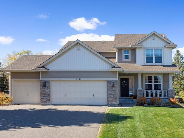 craftsman-style house with a garage, stone siding, a front lawn, and covered porch