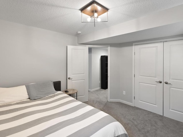 bedroom featuring a textured ceiling, a closet, carpet flooring, and baseboards